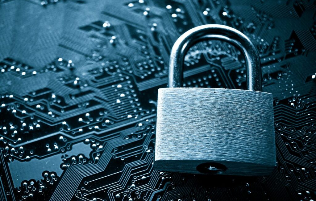 Kuvituskuvana metallinen lukko piirilevyn päällä.