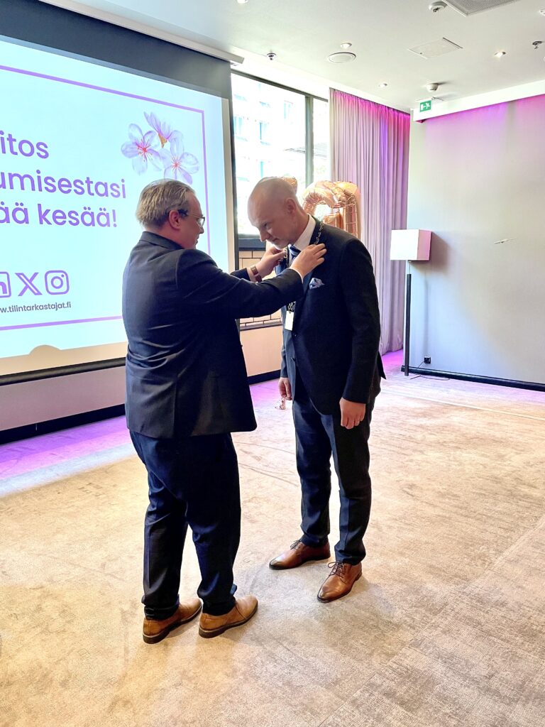 Kuvassa entinen puheenjohtaja Aleksi Martamo luovuttaa käädyt uudelle puheenjohtajalle Osmo Valovirralle.